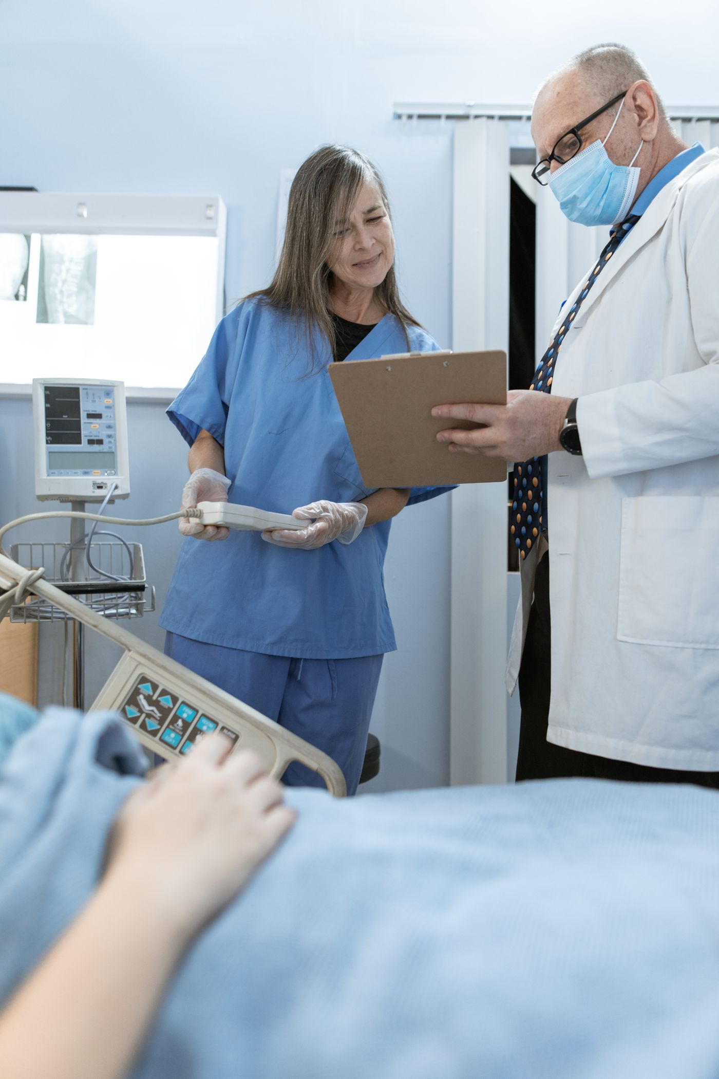 A nurse and a doctor conferring on a hospital ward