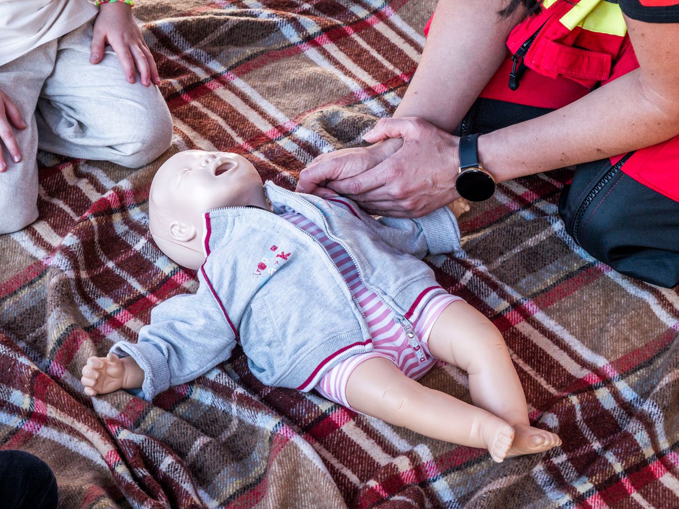 A paramedic practising infant CPR on a training manikin